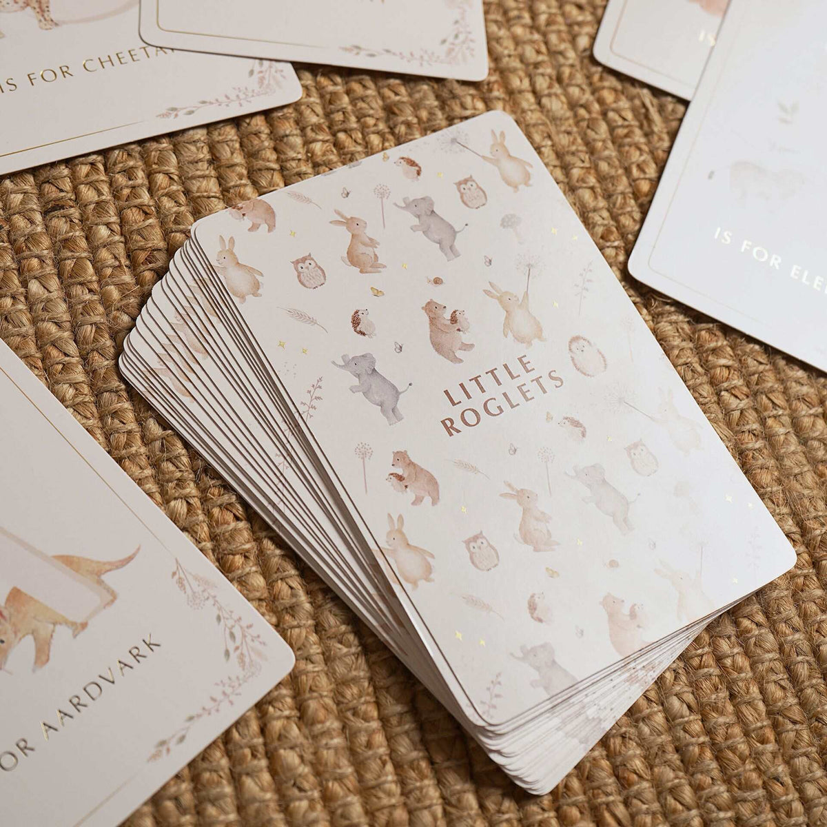 Close-up of the alphabet card backs with repeating animals and Little Roglets lettering.
