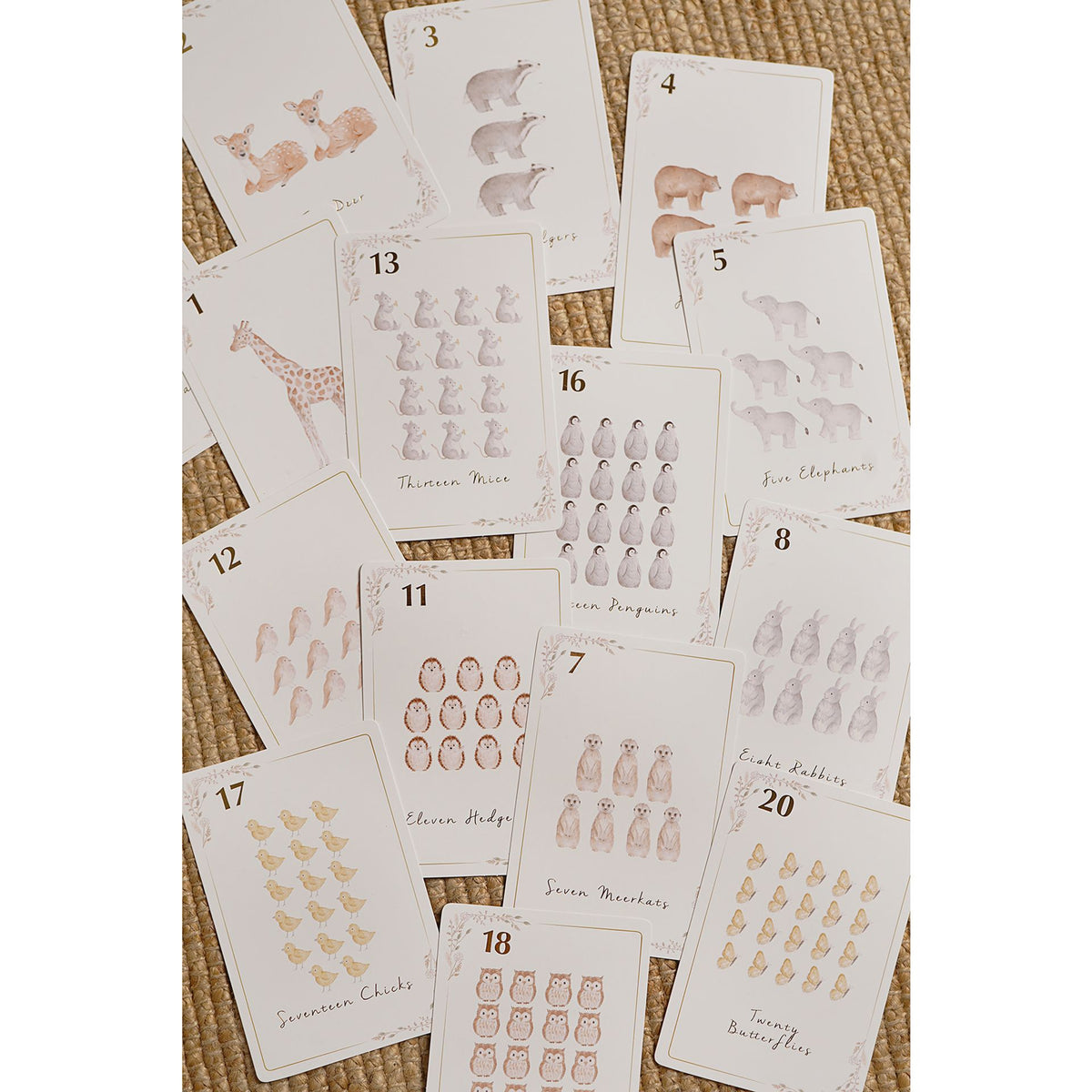 Assorted animal number cards on a woven background, with counting groups from across the set.
