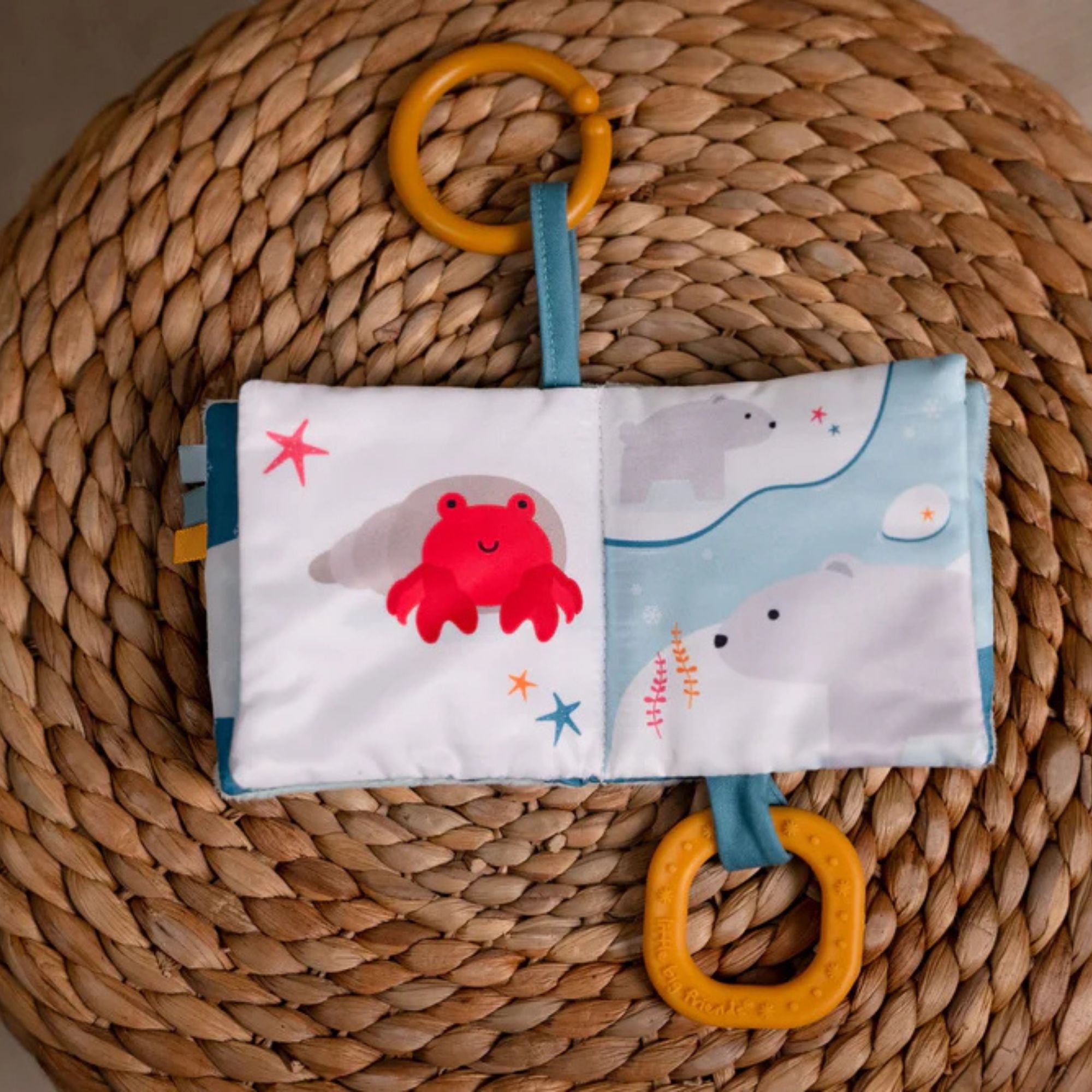 Soft ocean themed baby activity book with sensory pages, open on crab page
