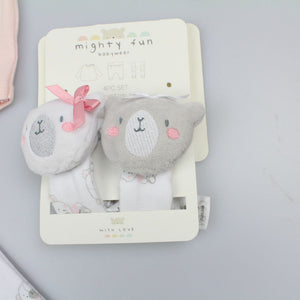 Close-up of two bear wrist rattles with pink cheeks, one with a pink bow, on their display card.