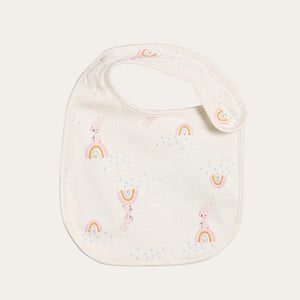 Cream baby bib with rainbow print and snap fastening