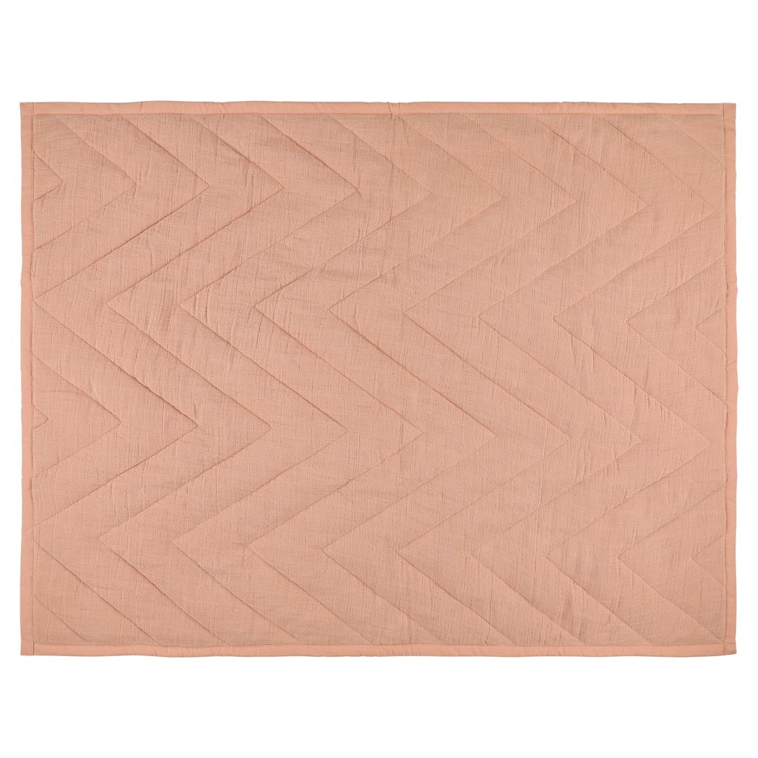 Baby blanket made from organic cotton in soft coral tones, suitable for nursery and everyday use