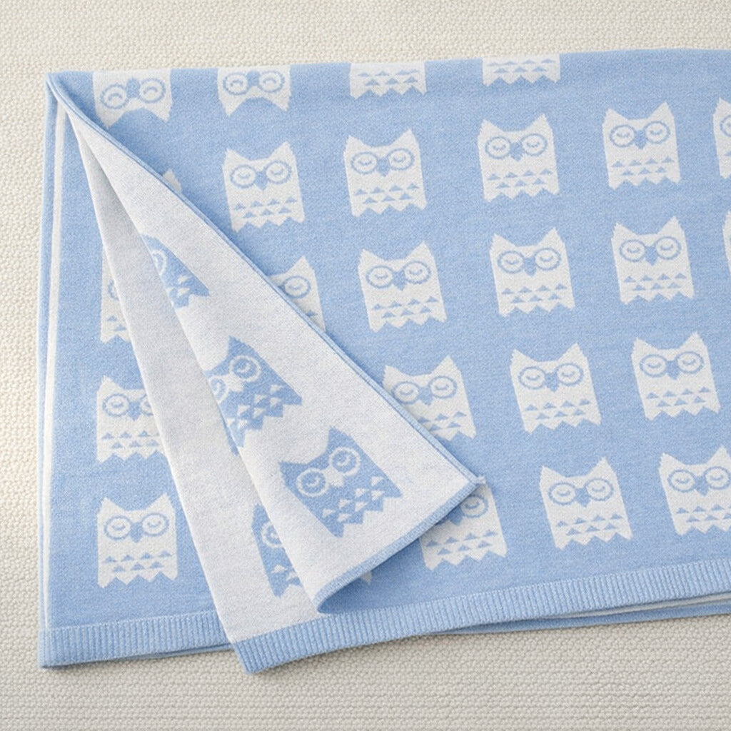 close up of owl print on blue baby blanket
