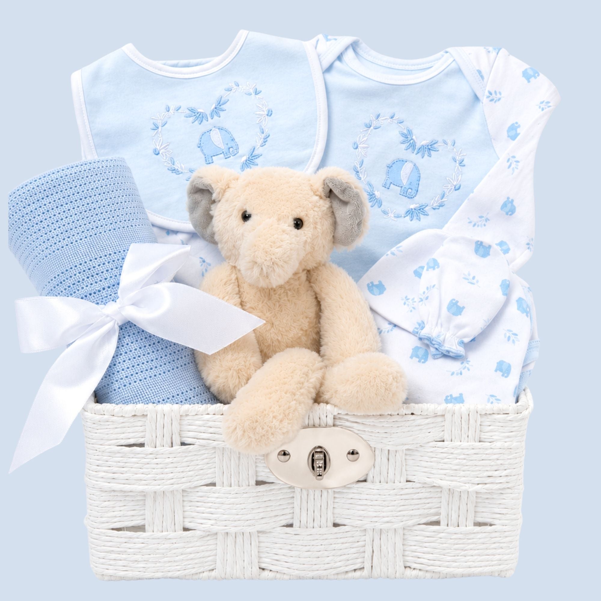 Baby boy gift basket with blue baby clothes, a teddy bear and a blanket.