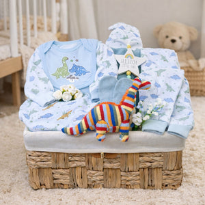 Present for a baby boy in a hamper with blue dinosaur clothing set.