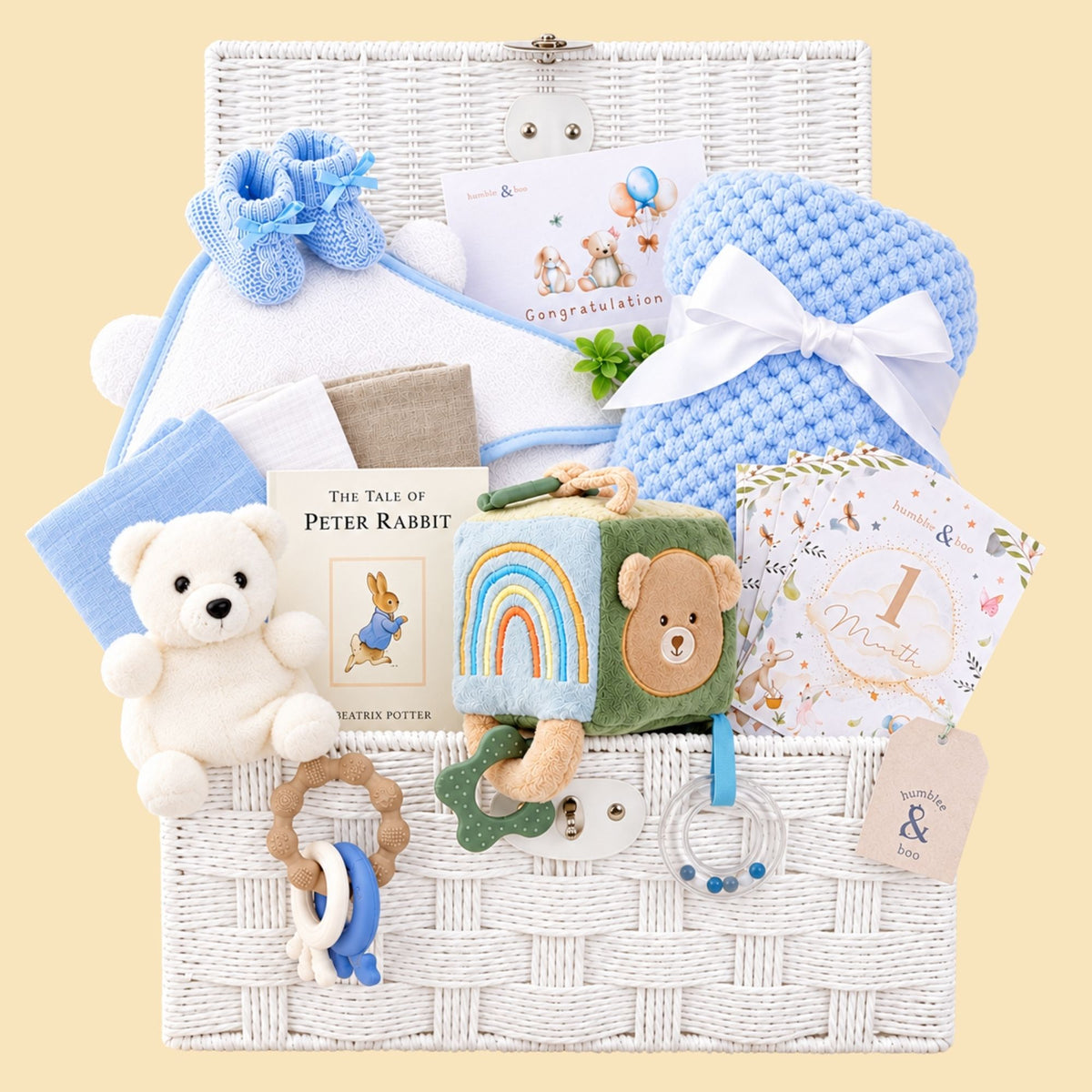 Newborn baby boy gifts with toys and books in a white hamper basket