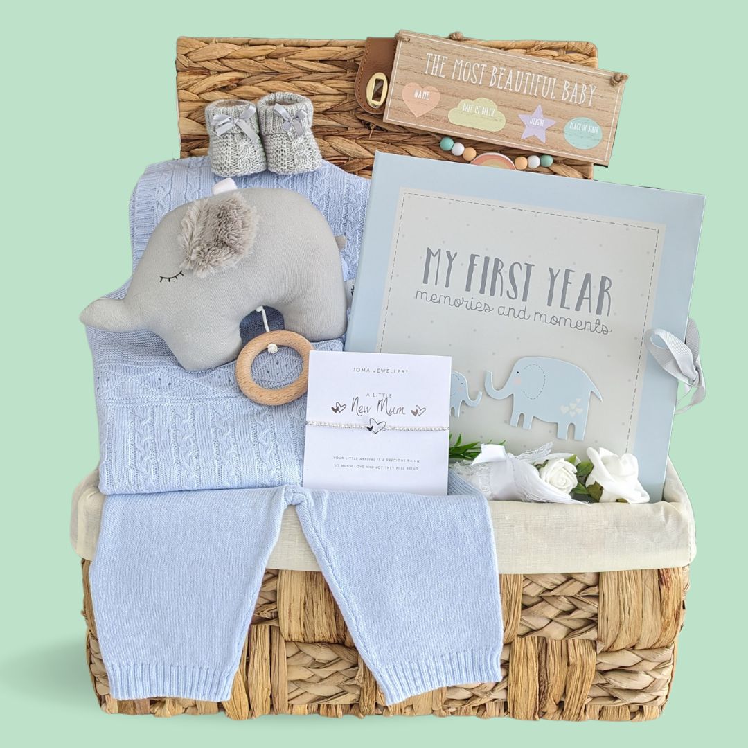 Beautiful basket for a new baby boy with cable knit clothing set, musical pram toy elephant, baby blanket, baby boy journal and a silver bracelet for a new mummy.