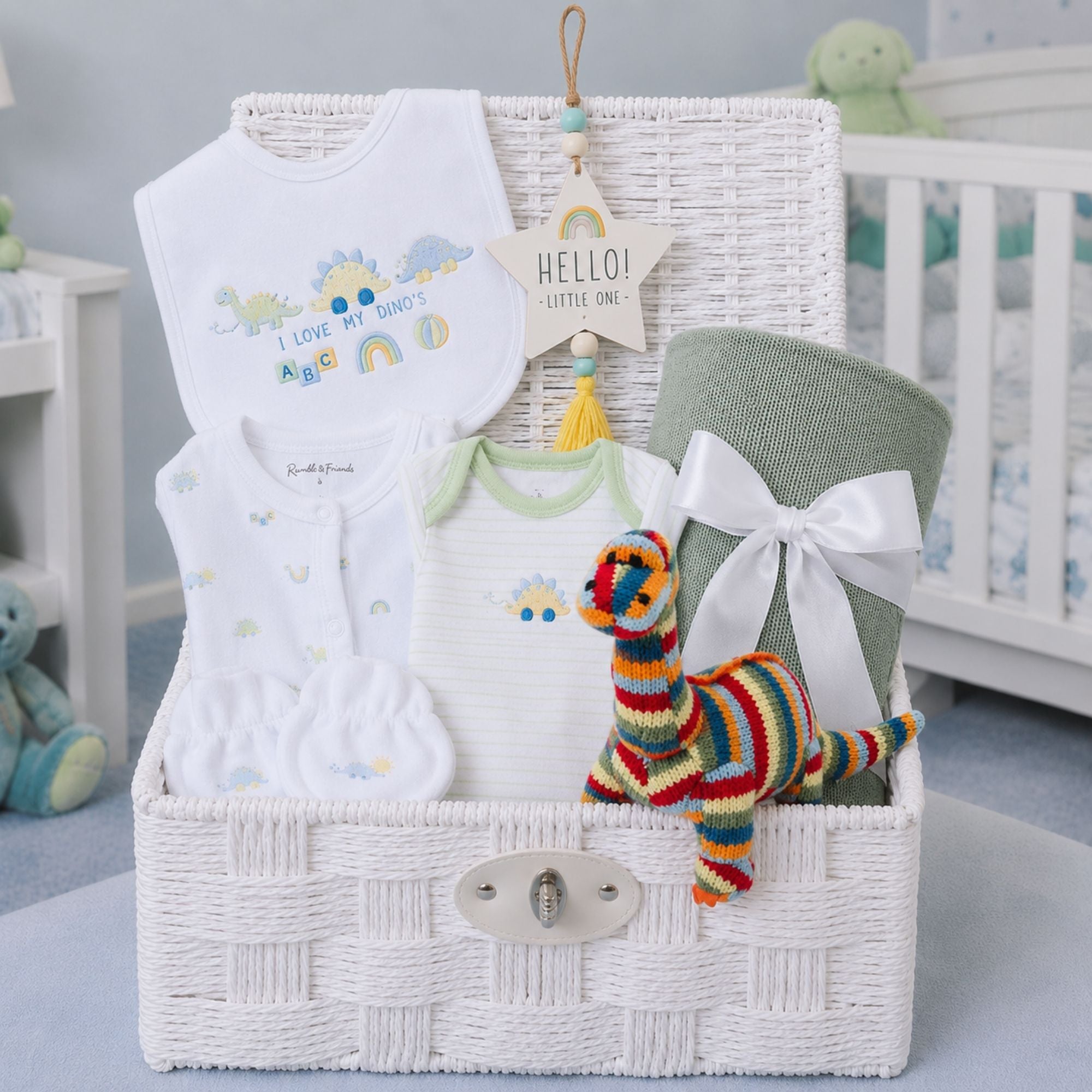 Dinosaur baby boy gift basket with clothing and an organic dinosaur rattle.