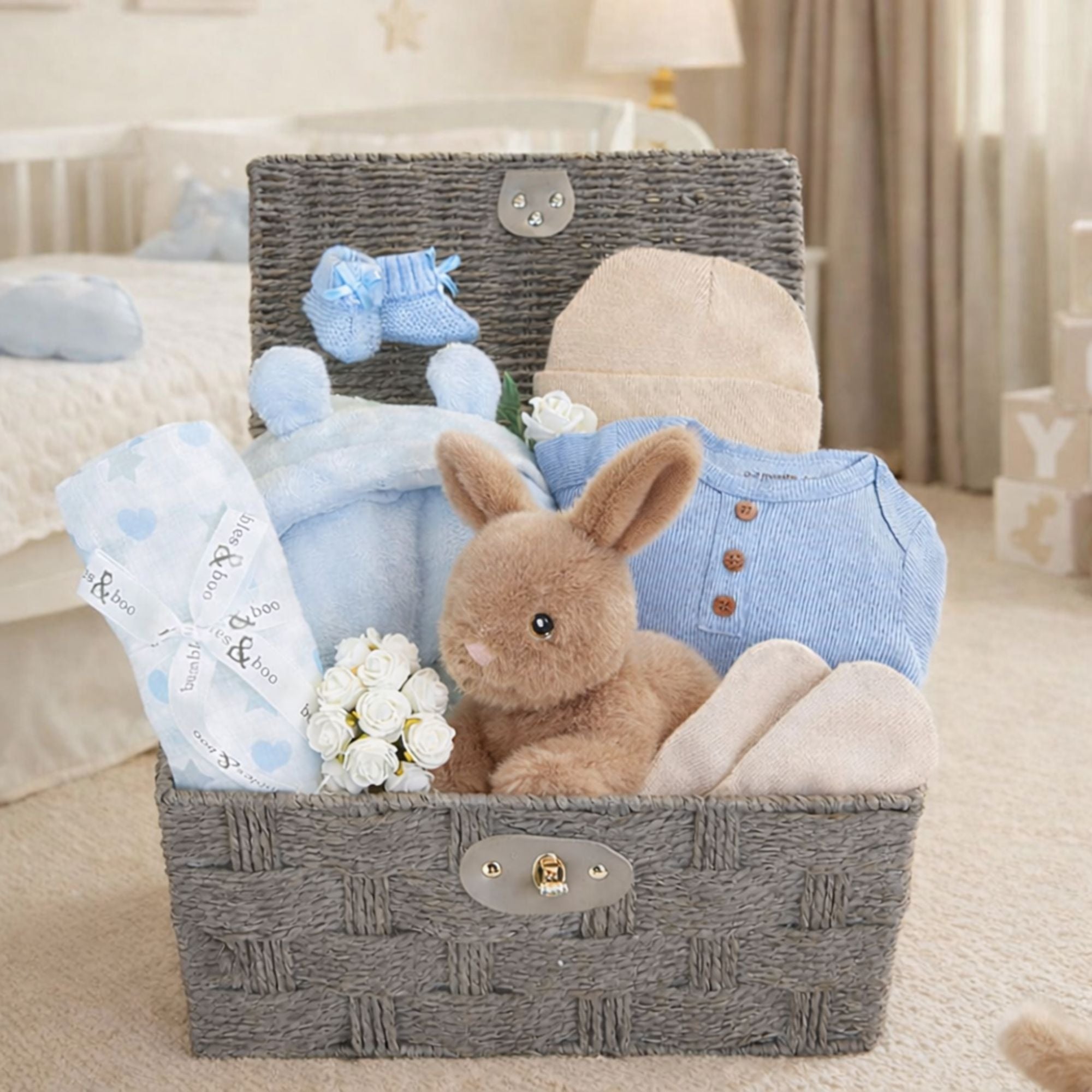 Baby boy gifts basket with a bunny rabbit and baby clothing in a hamper.
