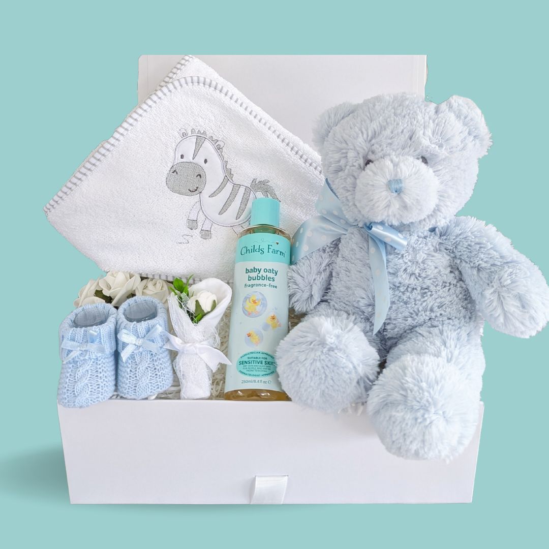 new baby boy gifts hamper with hooded bath towel, blue teddy bear, organic bath wash, baby knit booties and scratch mittens.