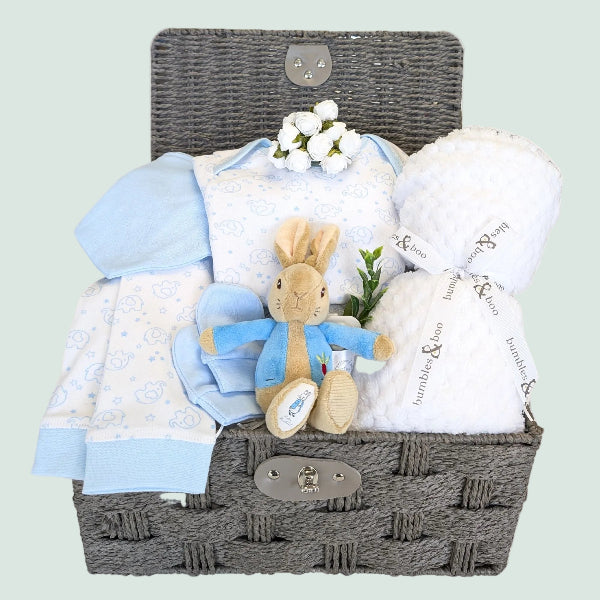 Baby boy gifts hamper with white blanket, bandana bib, pyjamas and peter rabbit soft toyin a basket
