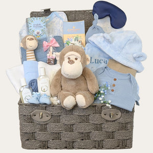 Large luxury hamper basked filled with gifts and presents for a new baby boy with a blue and monkey theme. A gift by Bumbles and Boo. 