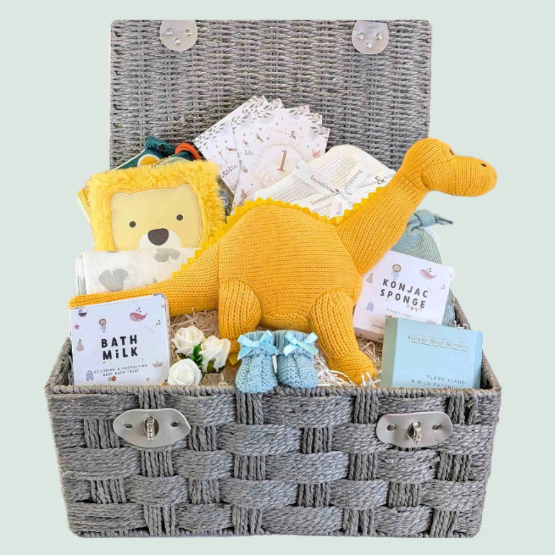 Large baby boy hamper with gifts including yellow organic knit dinosaur and blue baby booties. Bumbles and Boo.