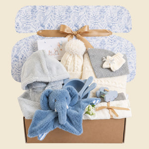 Gifts hamper for a baby boy with a knit hat and blanket set presents and blue elephant comforter soft toy.