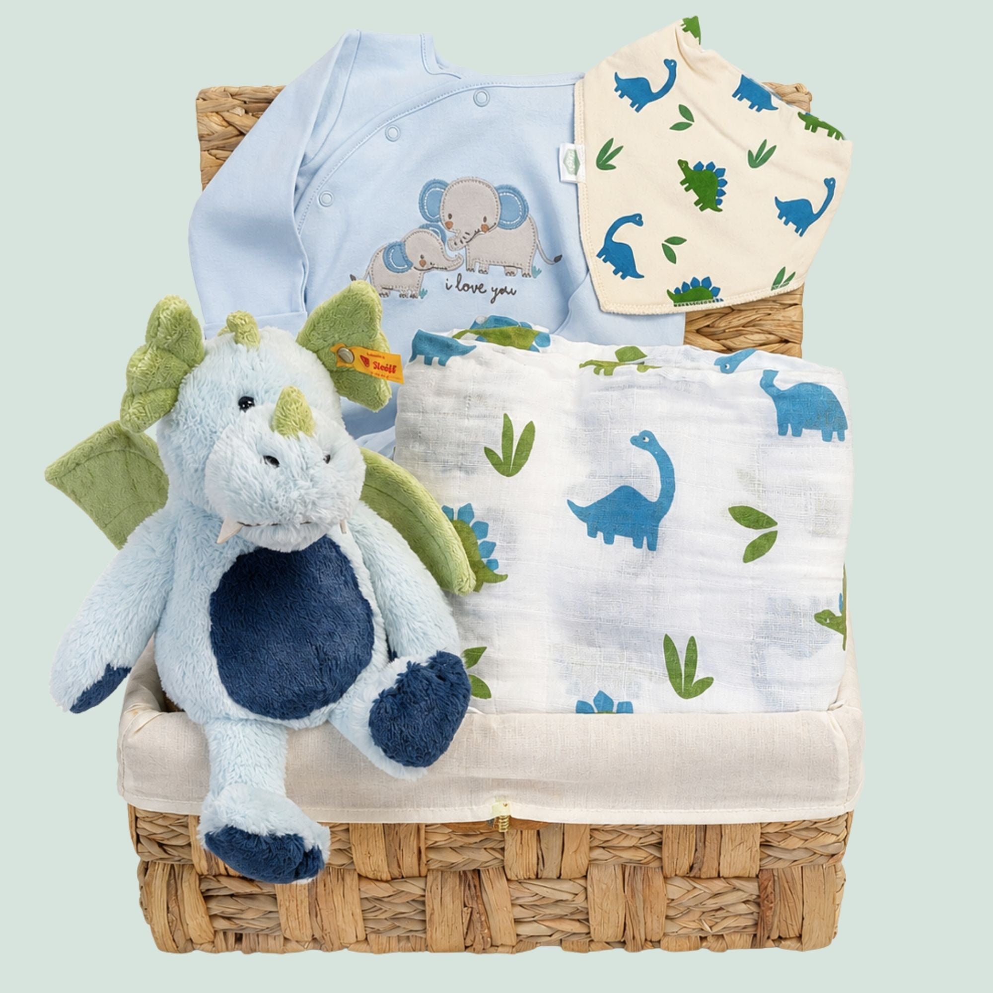 Baby boy gifts in a basket with a steiff dragon and dinosaur theme.