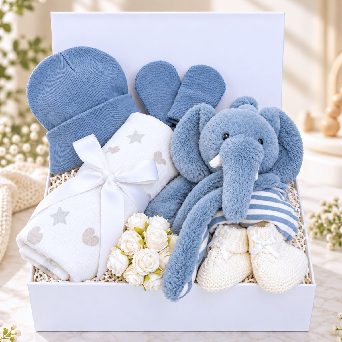 Baby boy hamper with blue eco elephant comforter in a white gift box with blue baby accessories 