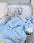 baby boy gifts trunk with blue elephant comforter blanket, blue knit baby booties and scratch mittens.