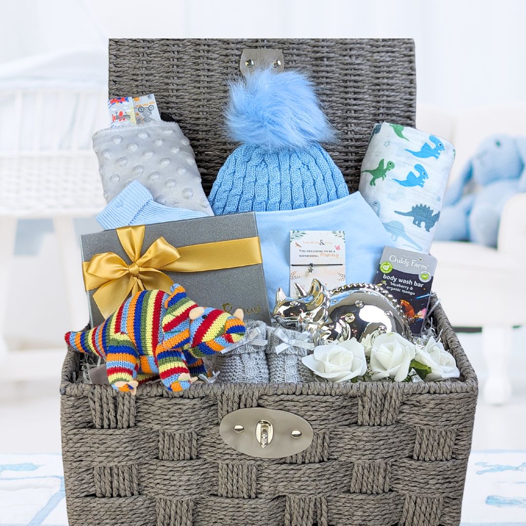 baby boy hamper basket with dinosaur theme. Hat, muslin, bib, taggie and chocolates for the new parents.