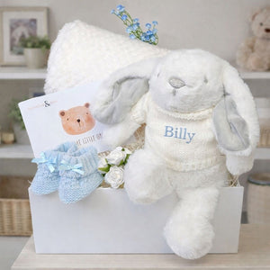 A gift box for a baby boy with a personalised white bunny and white fleece blanket.
