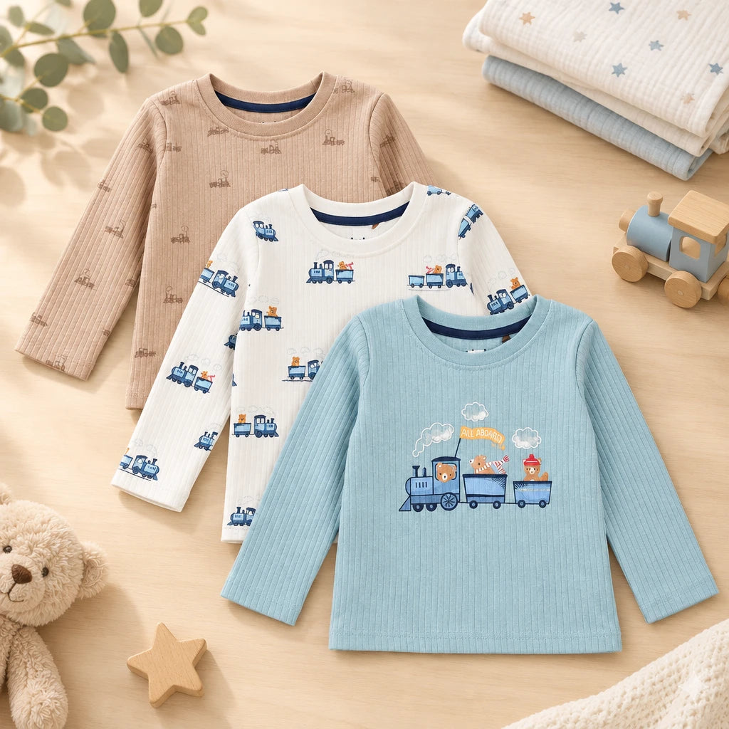 Three long sleeve baby T-shirts in beige, white and blue train prints arranged together.