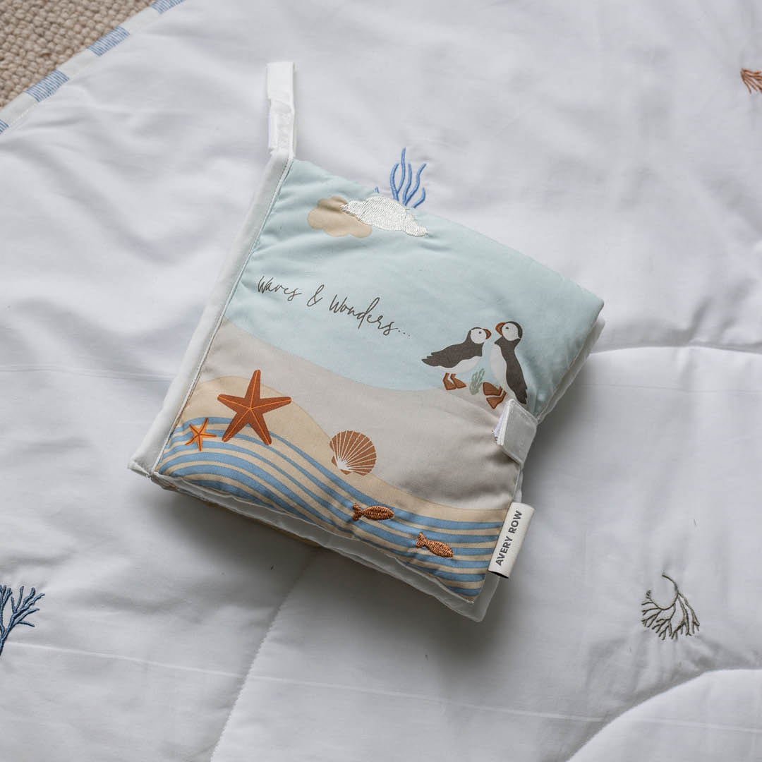 Folded Coastline baby fabric book showing its seaside cover and attachment loop.