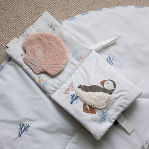 Open Coastline fabric book with a puffin illustration and pink shell detail.