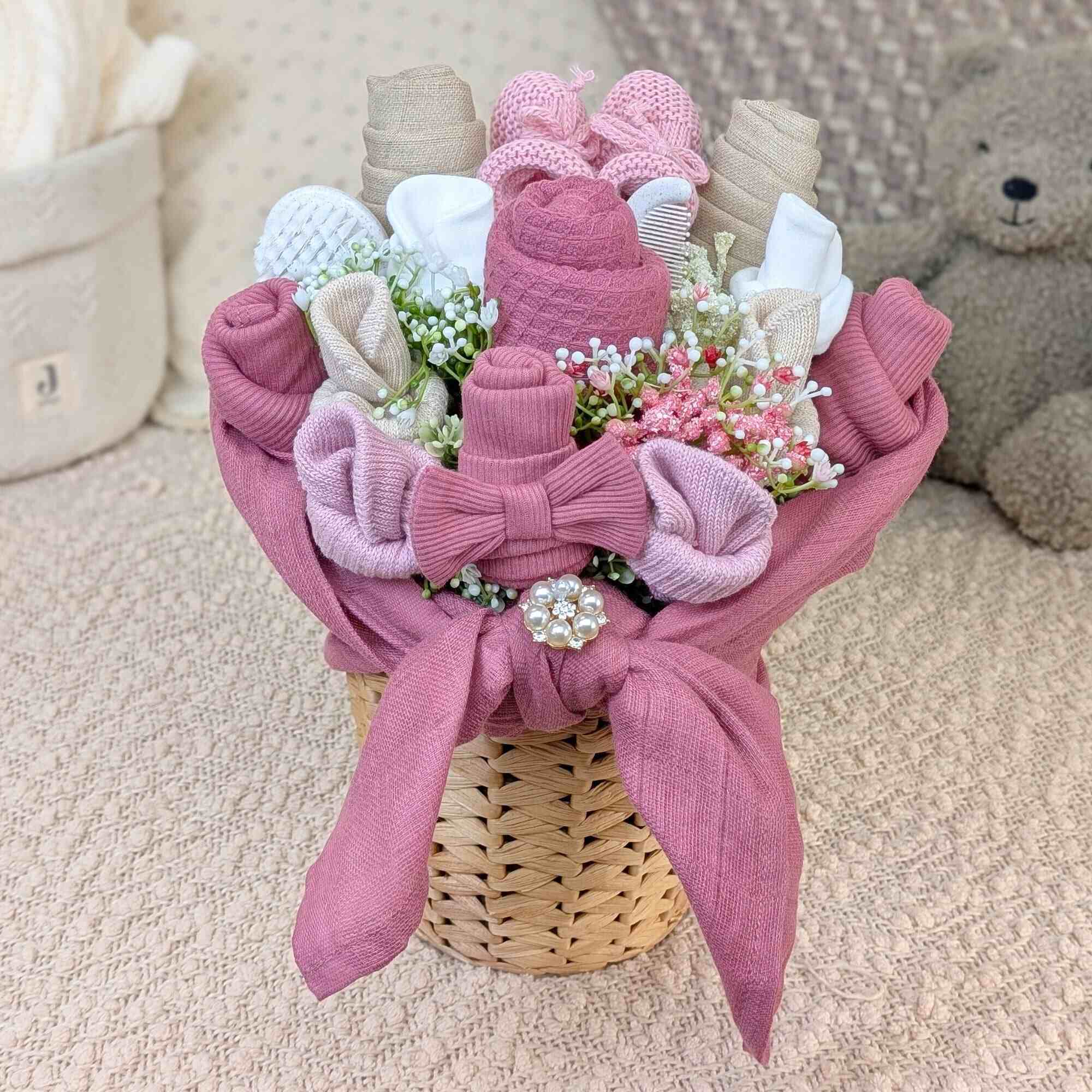 Pink flower bouquet made of baby clothes and accessories for a baby girl.
