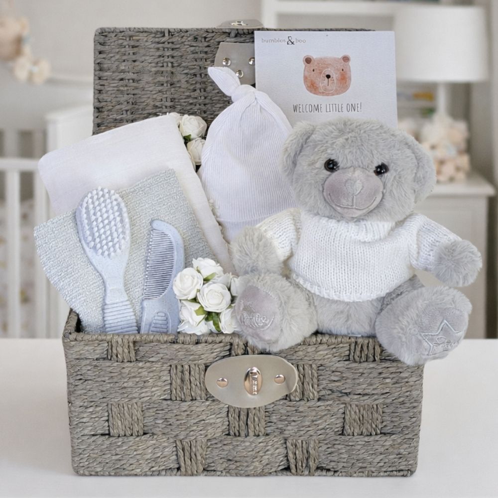 A baby hamper with gifts including teddy bear and baby essentials in a basket 