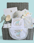 Baby gifts basket containing baby clothing, organic elephant soft toy, baby milestone cards, photo album and baby knit booties.