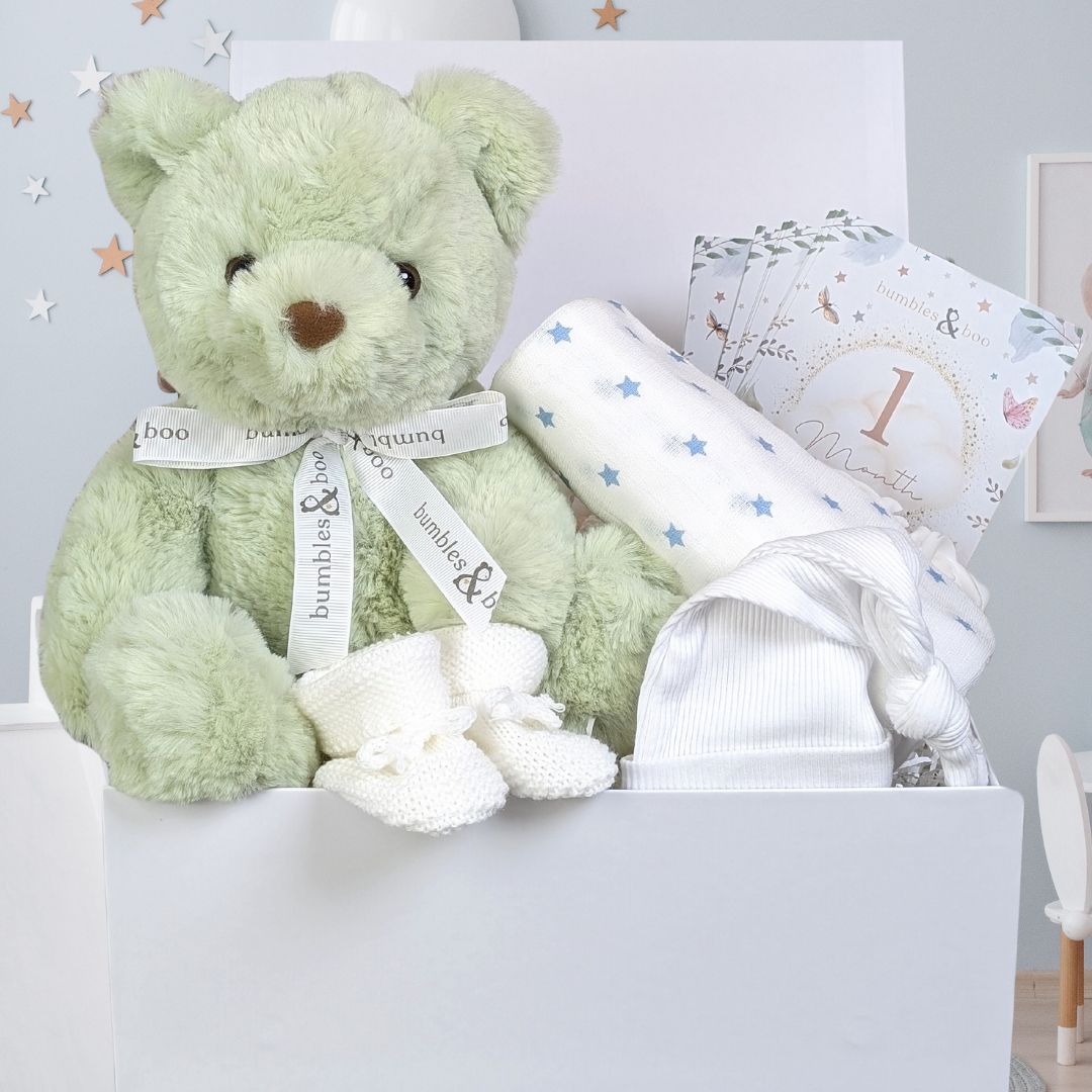 Baby gift box with green teddy bear and baby essentials