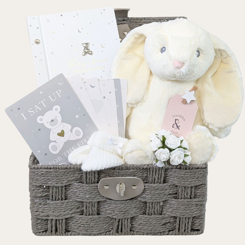 Baby gift hamper basket with white baby journal and milestone card set and large white bunny toy.