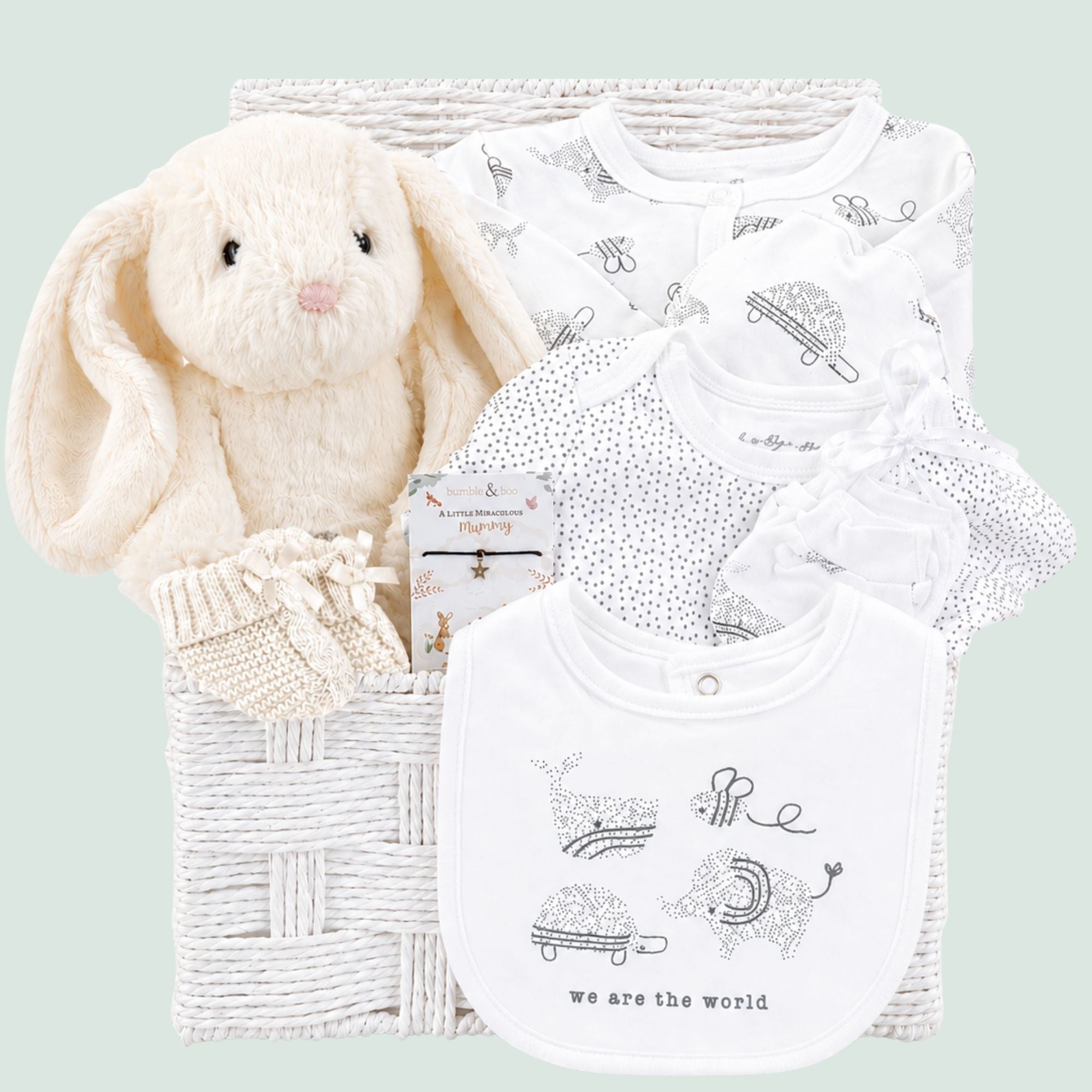 Baby gifts hamper basket with white baby clothing and cream bunny rabbit in a white basket.