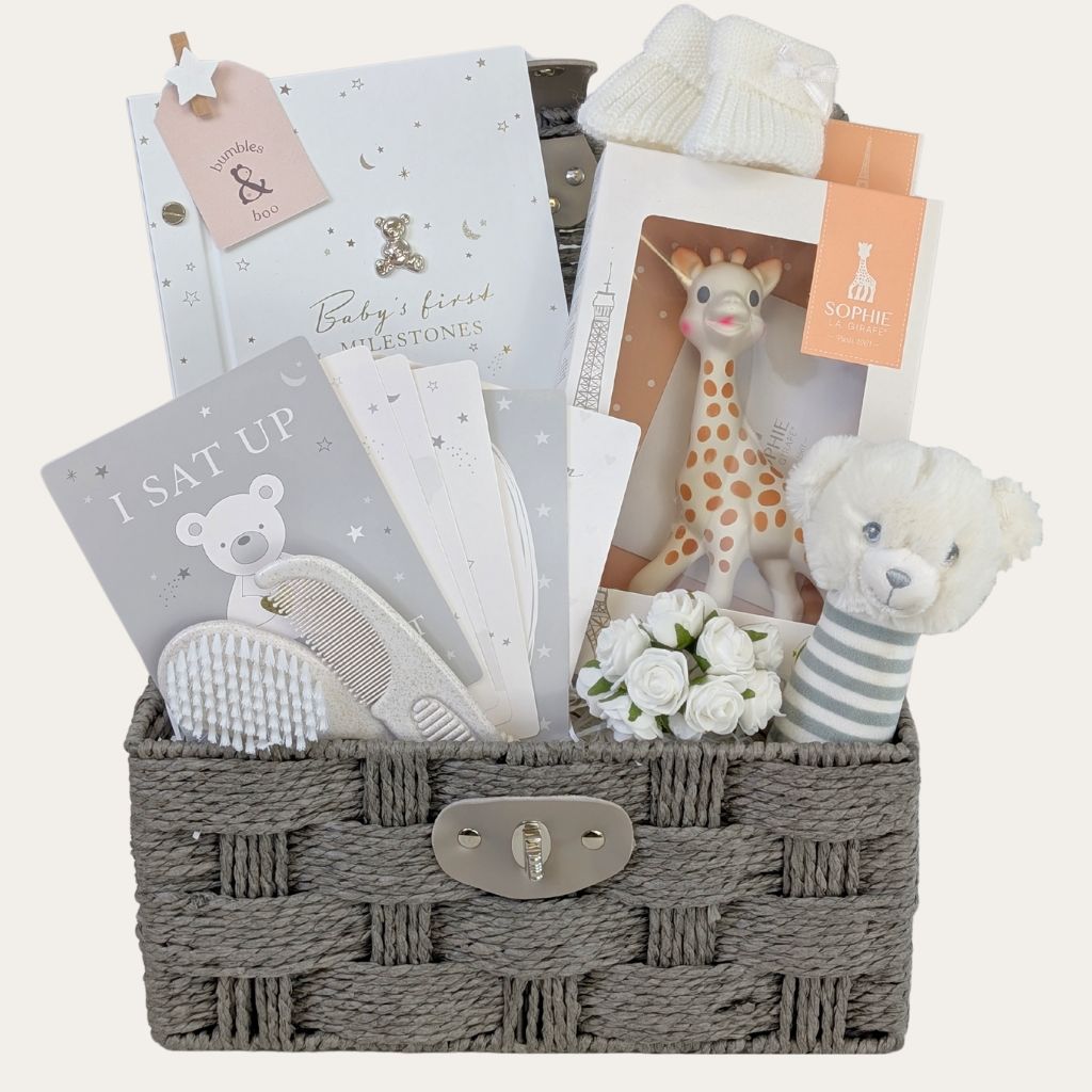 New baby gifts hamper featuring Sophie la Giraffe teether and sensory toys in a wicker basket