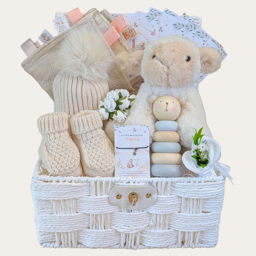 New baby gifts basket with soft beige and cream tones and includes a lamb plus toy.