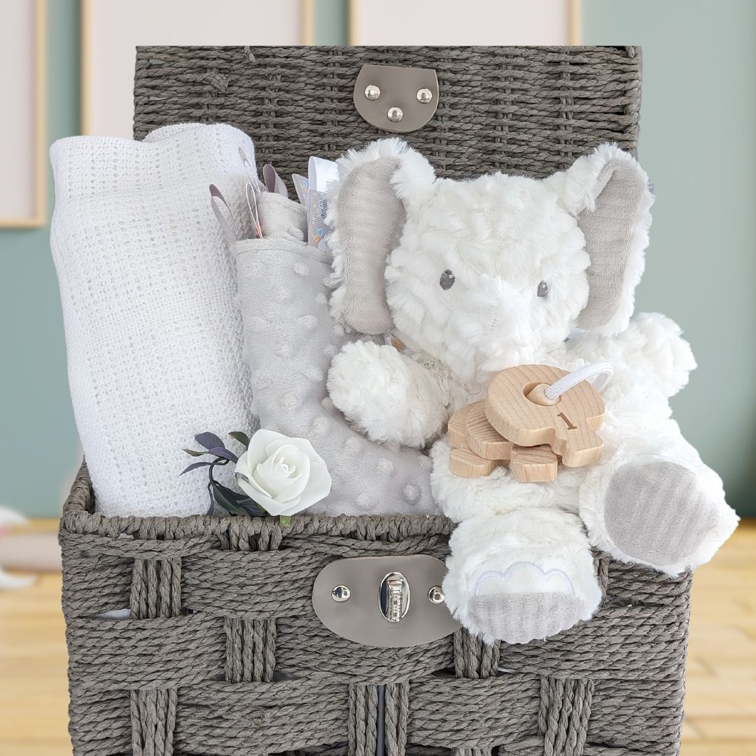 baby gifts basket with elephant, blanket, taggie and teething keys.
