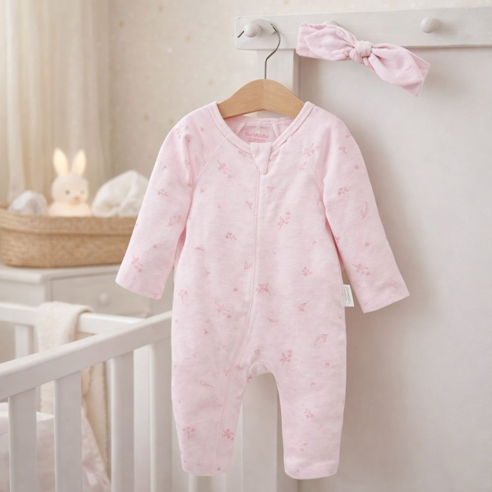 A pink baby girl sleepsuit romper in organic cotton with a pink head band