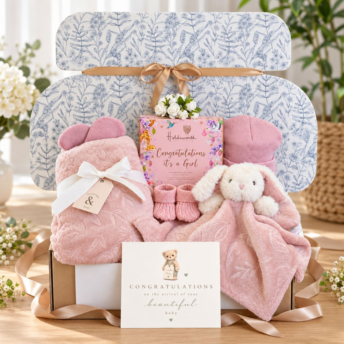 Baby girl gifts box with presents including pink blanket and matching comforter