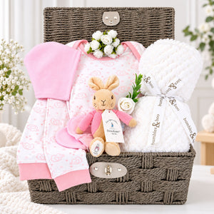 Baby girl hamper basket with gifts of pink pyjamas, white baby blanket, and bunny soft toy.  Bumbles and Boo.