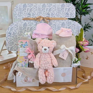 Baby girl gifts box with a pink teddy and lots of presents including biscuits for mum. Presented in an eco friendly hamper