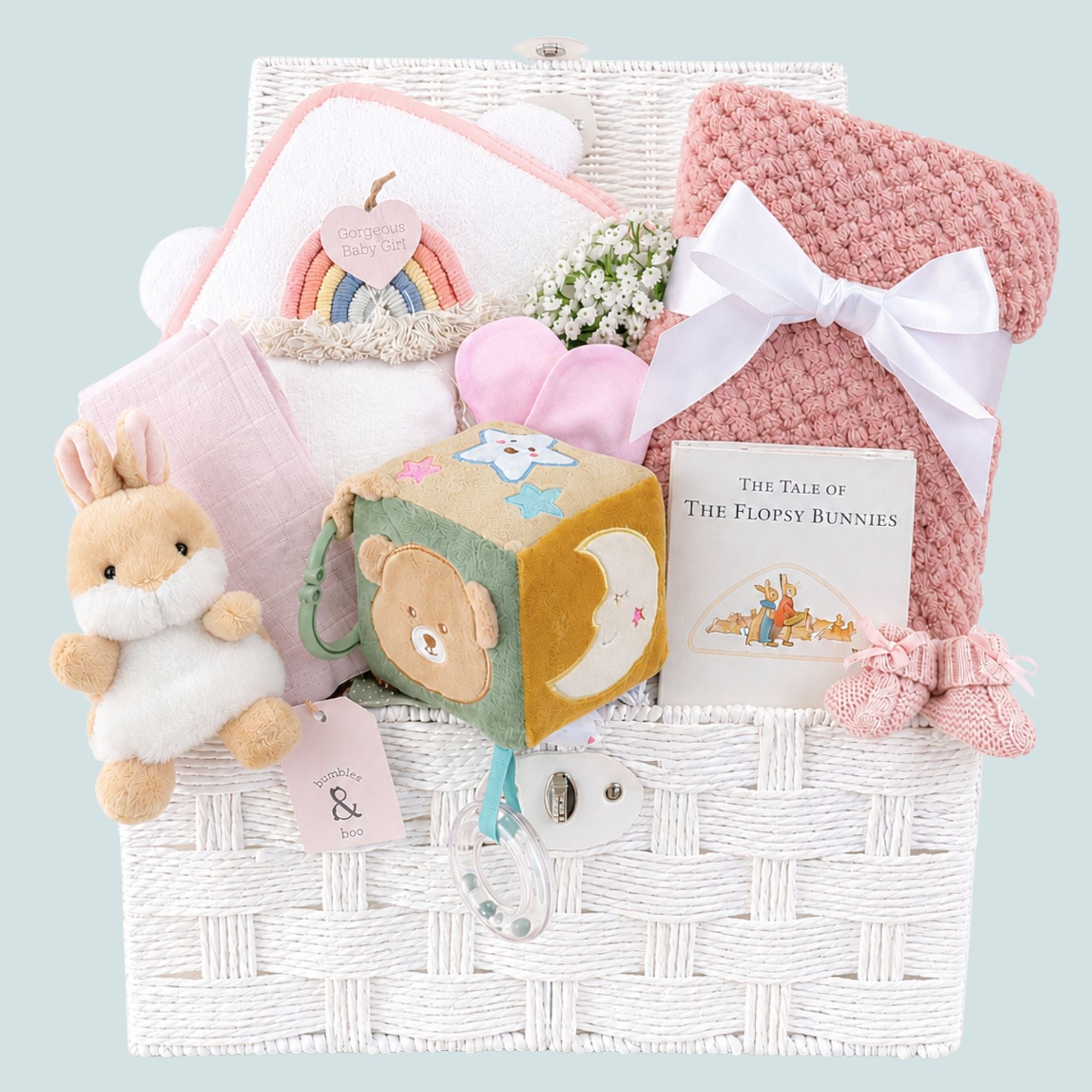 Baby girl gifts hamper with congratulations presents with a bear and bunny theme in a white gift basket.