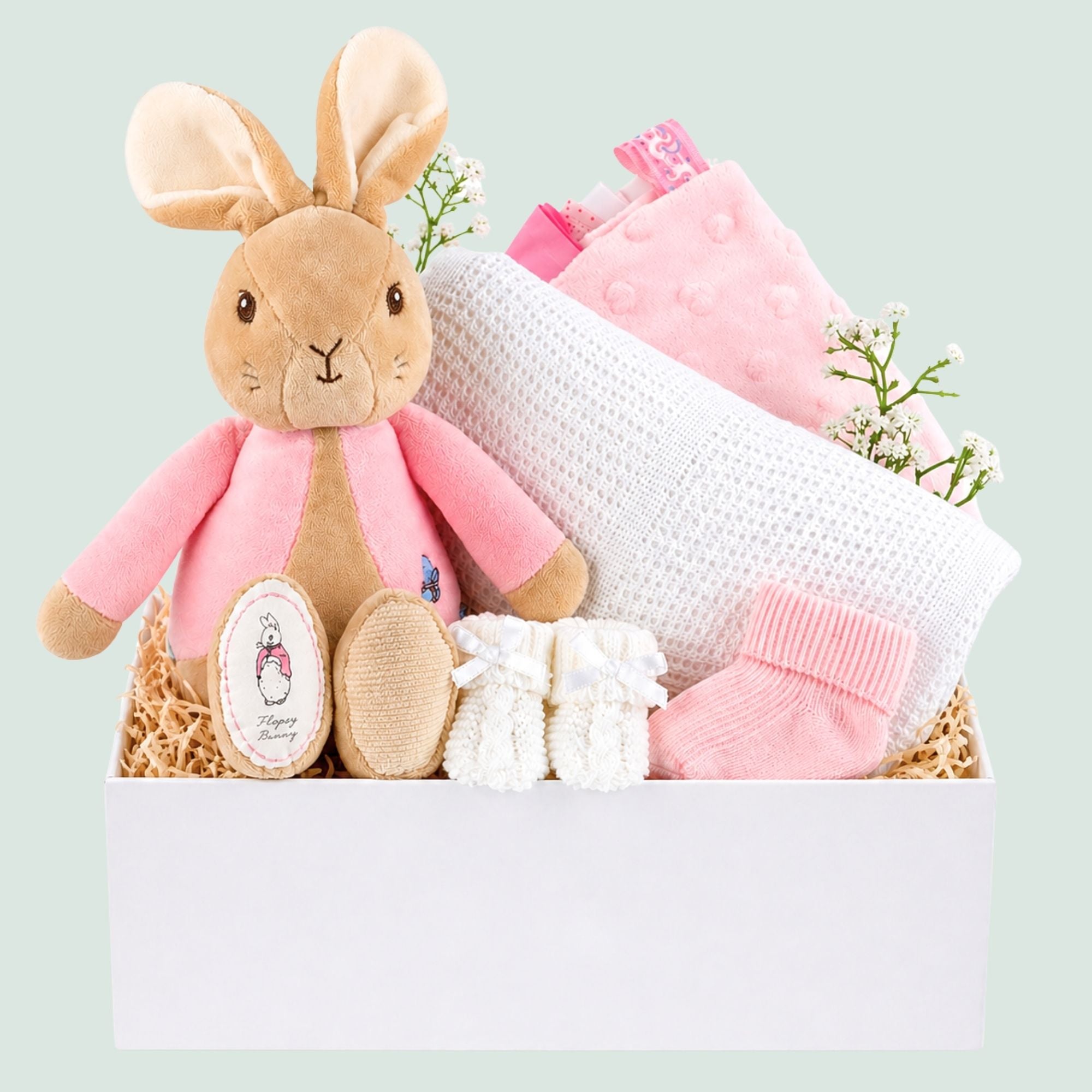 Baby girl hamper with gifts including a pink flopsy bunny soft toy and white baby blanket in white gift box by Bumbles and Boo.