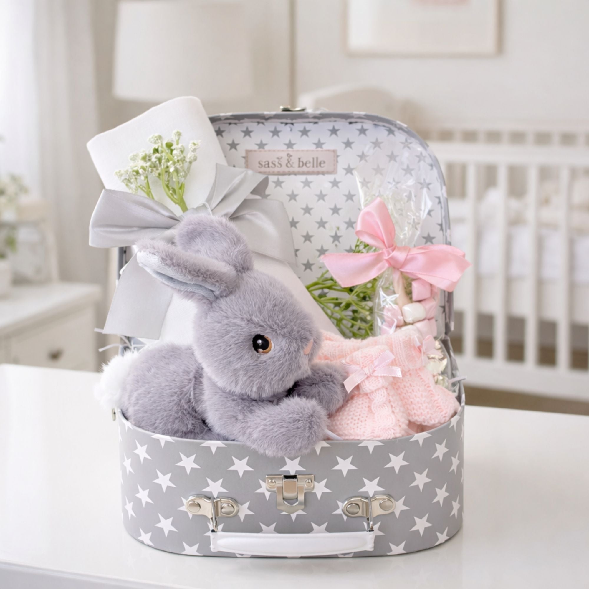 Grey suitcase baby girl gifts in a hamper with bunny rabbit and presents for baby plus chocolates for mum