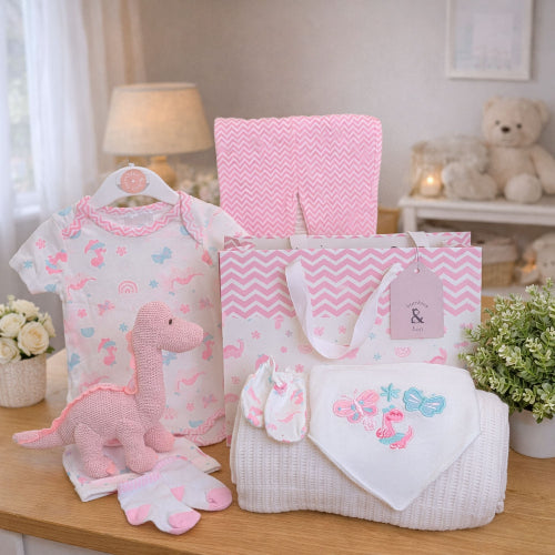 Baby girl gifts set in a bag with pink organic dinosaur rattle, blanket and clothing set.