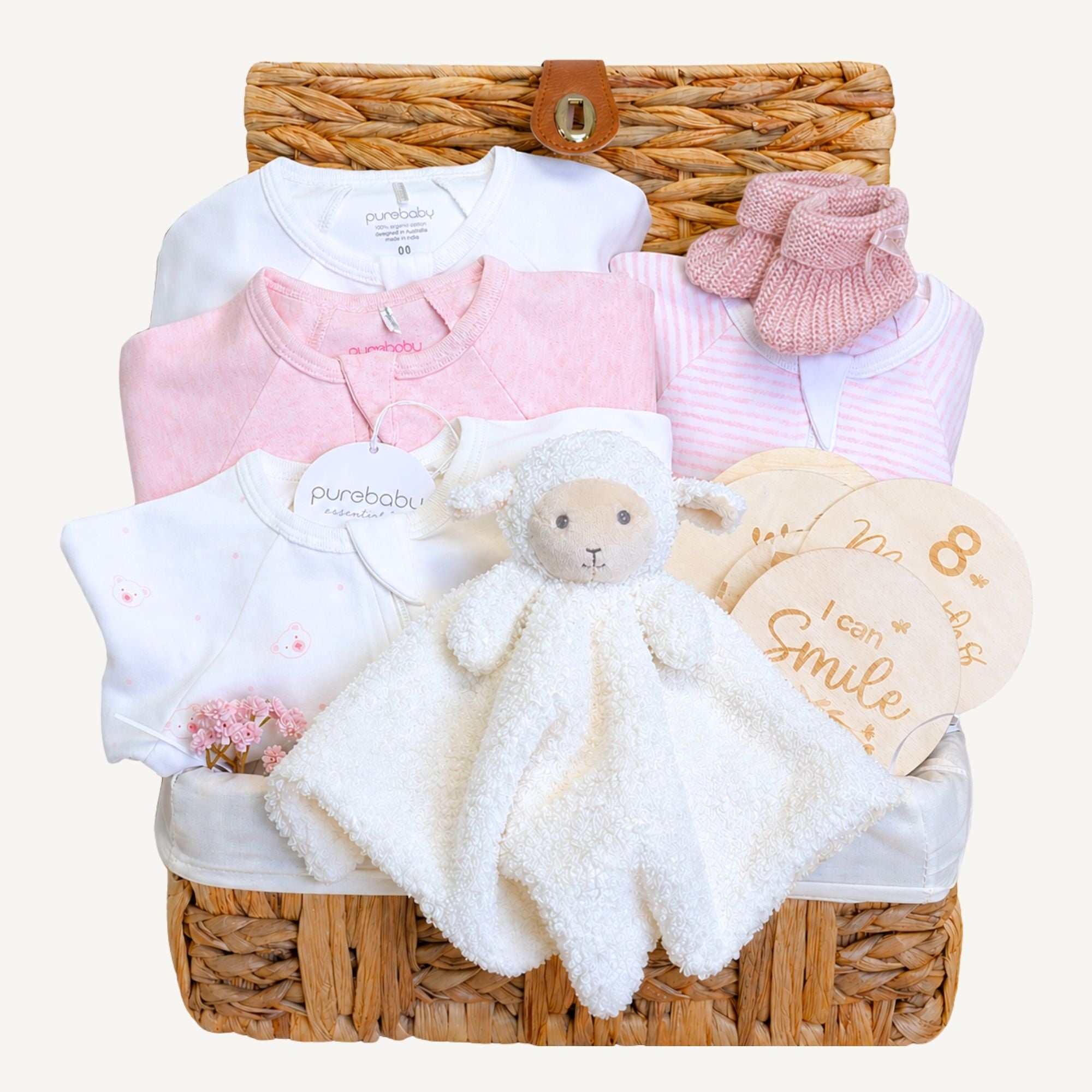 Baby girl gifts hamper basket with pink & white baby clothes set and presents including milestone discs and lamb soft toy.