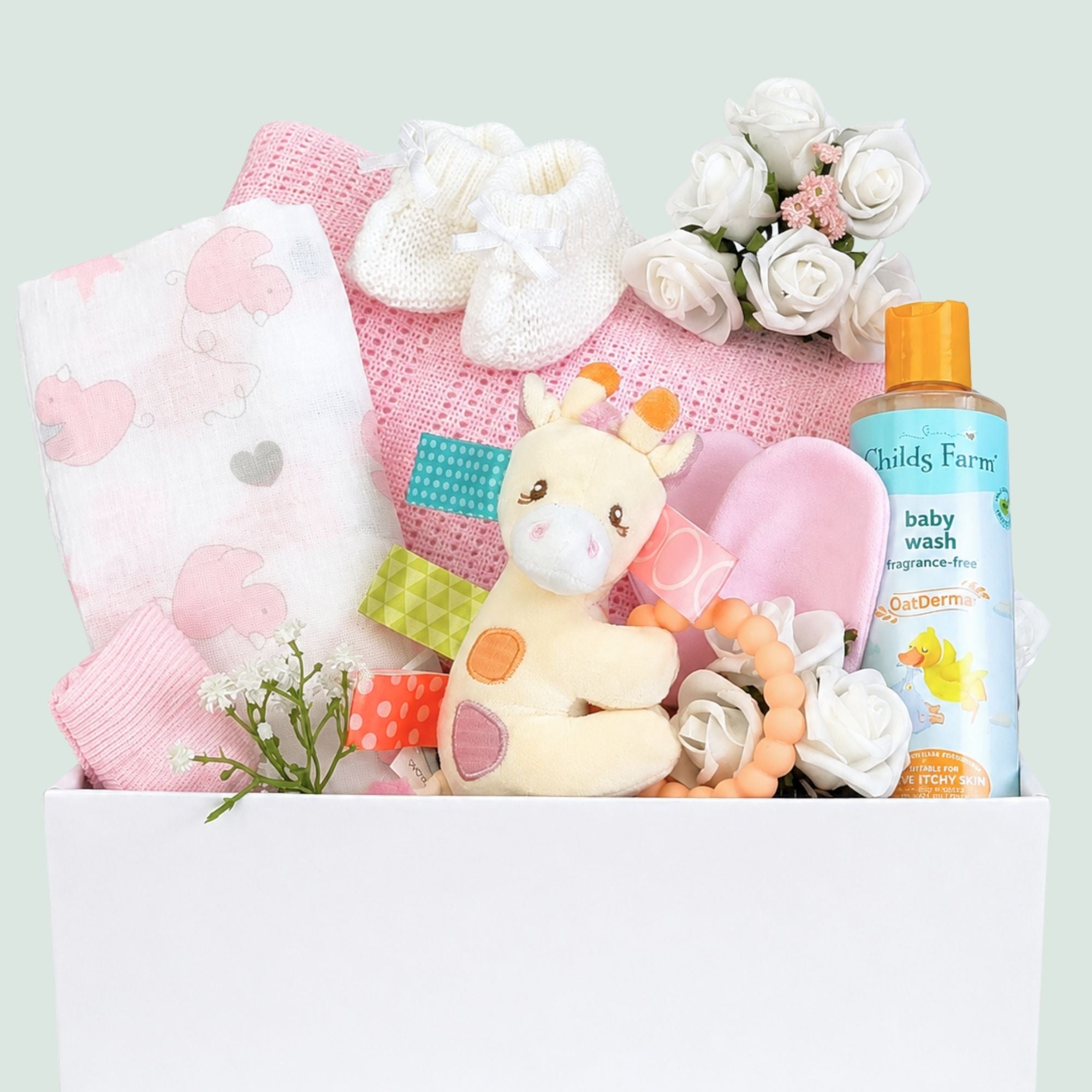 Newborn baby girl hamper. This white gifts box contains presents including a pink cellular blanket, muslin square and tilly giraffe teether. Bumbles and Boo.