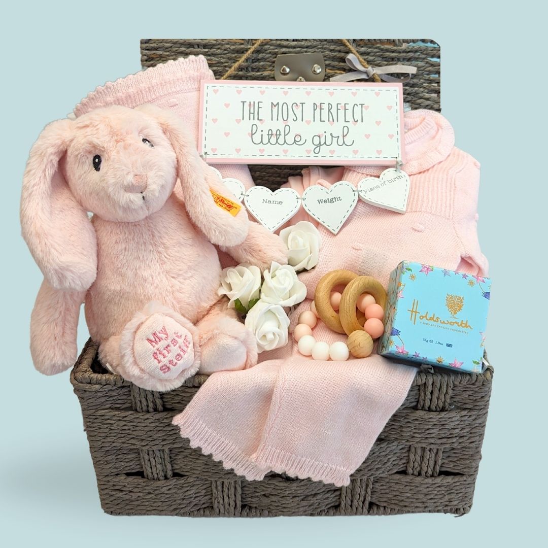 Baby girl hamper with stunning floral lilac clothing set, Steiff cuddly bunny soft toy and wooden baby teething toy. Award winning baby hampers perfect baby gifts for a new baby / baby shower.