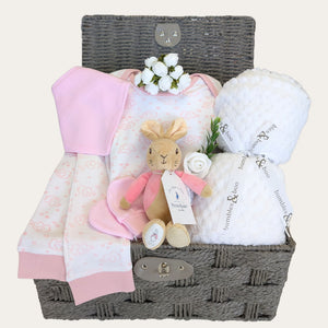 Baby girl hamper basket with gifts of pink pyjamas, white baby blanket, and bunny soft toy.  Bumbles and Boo.