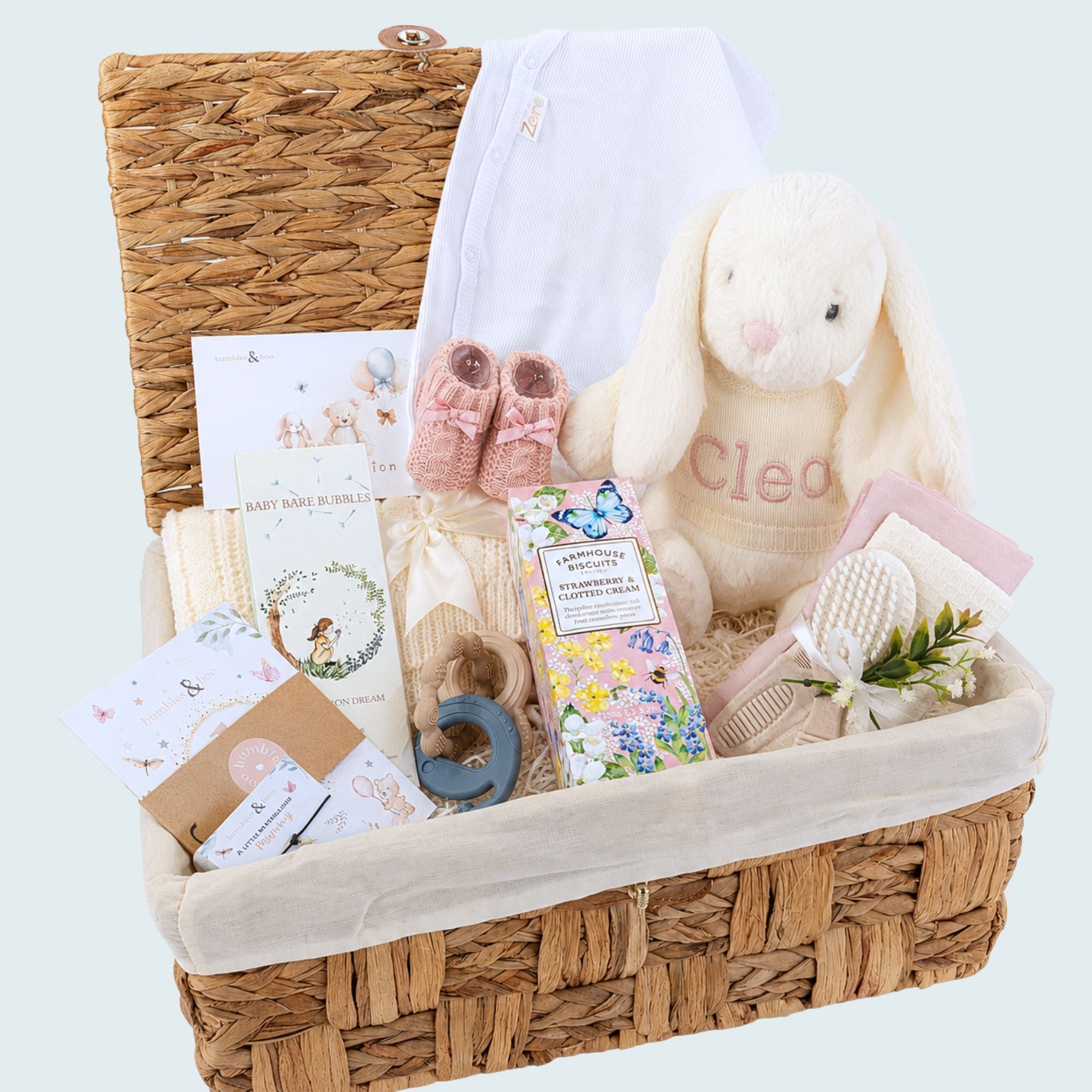 Baby girl hamper gifts in a basket with cream bunny rabbit, blanket and gifts for the parents too.