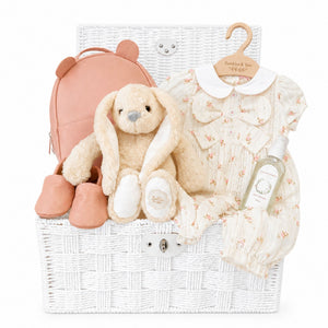 Luxury baby girl gifts hamper featuring a floral romper, plush bunny, baby shoes and keepsake gifts. A beautiful newborn gift for baby girls.