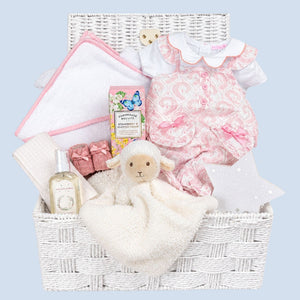 Baby girl hamper basket with pink romper and personalised hooded towel. Little lamb comforter in white.